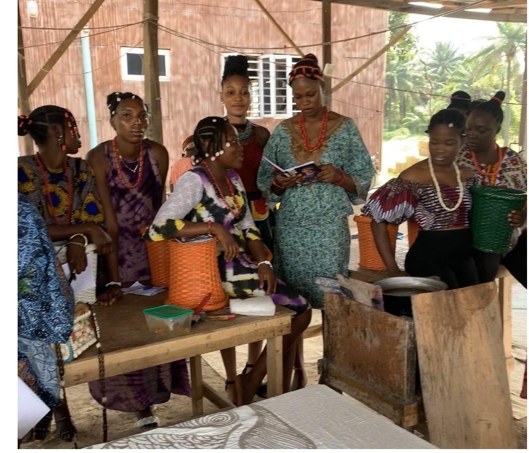Teaching contestants of the 2022 Cultural Pageant how to recycle old clothes using the tie-dye method